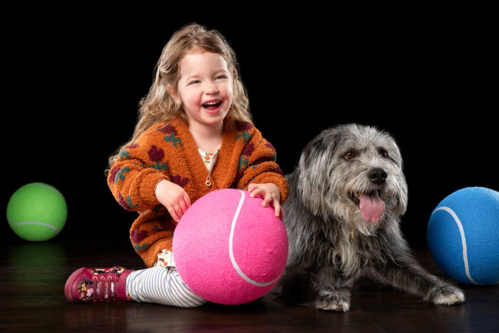 Child hugging their dog during a family portrait session with Chicago dog photographer Candice Cusic at Cusic Photo.
