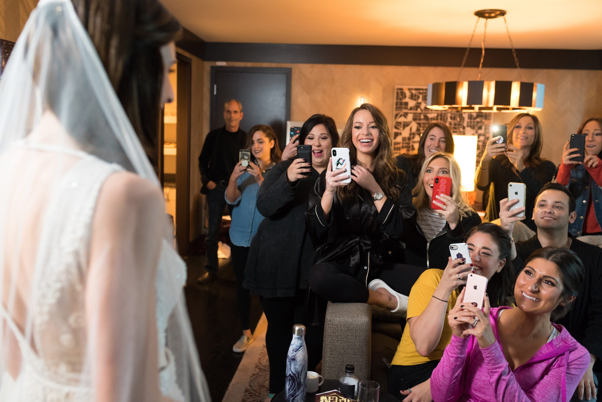 Wedding party and supportive family photographing bride Elana with wave of iphones. Photographed by Candice Cusic