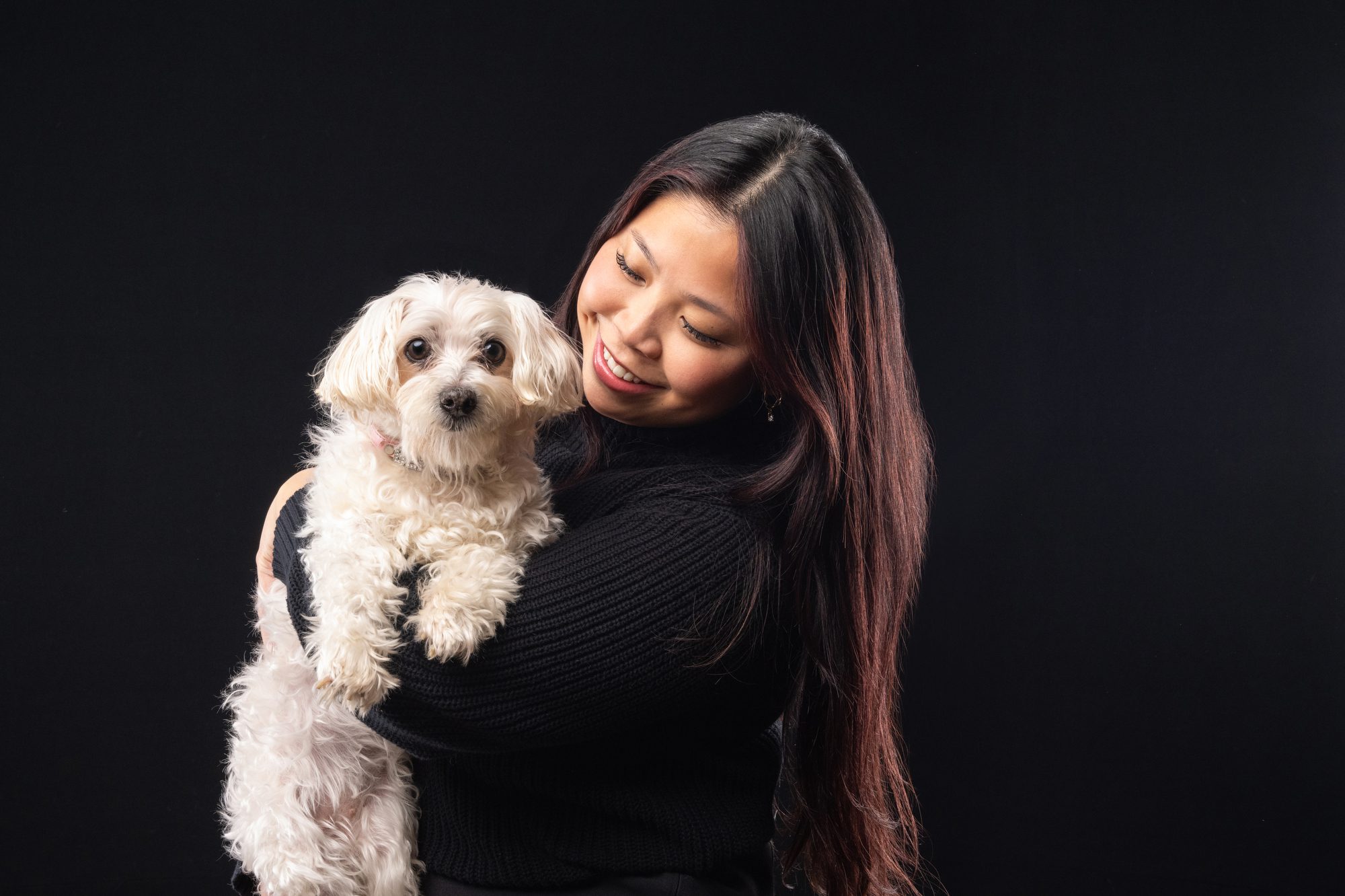 A young woman kisses her elderly Maltese photography by Candice C. Cusic