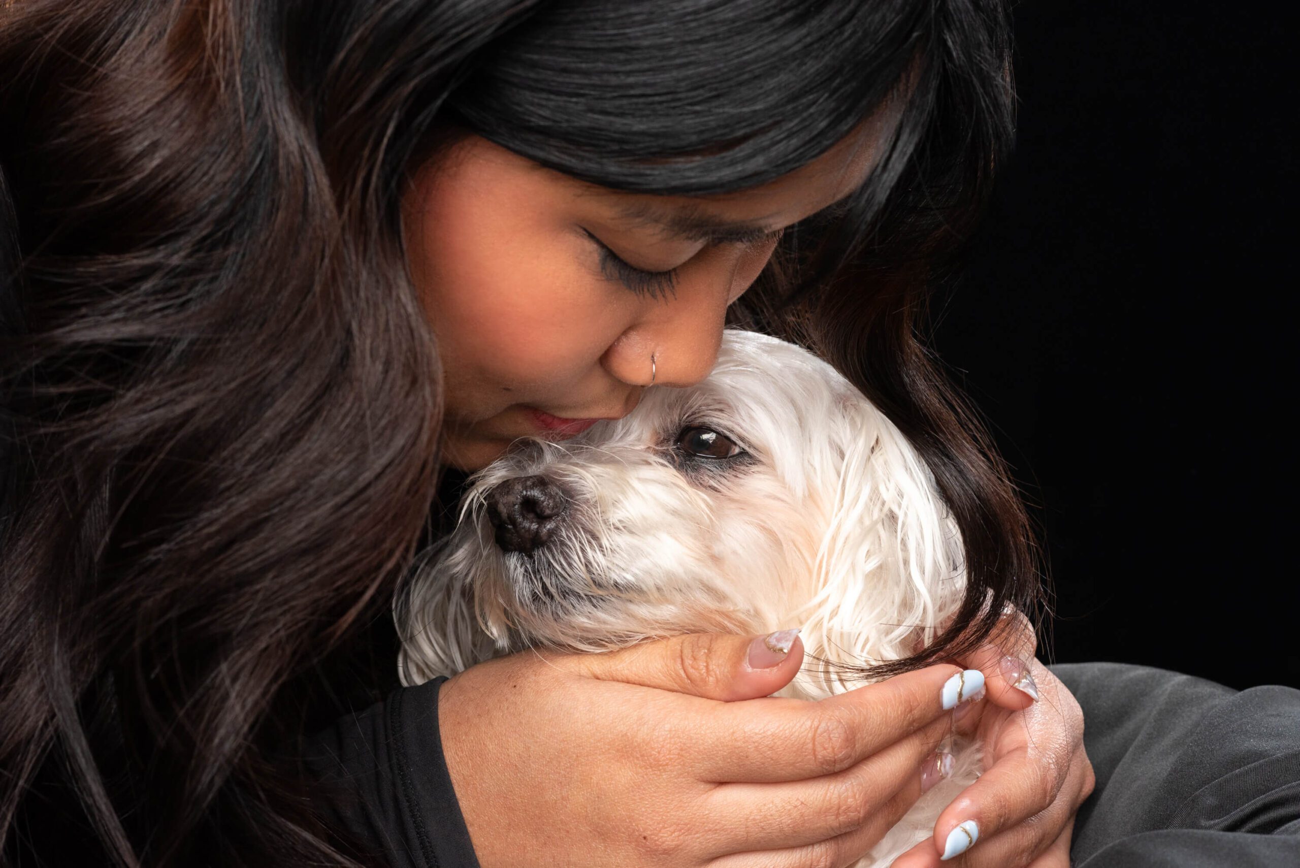 Animal communicator & photographer, Candice C Cusic, and her clients: woman with dark hair up close with dog with white fur