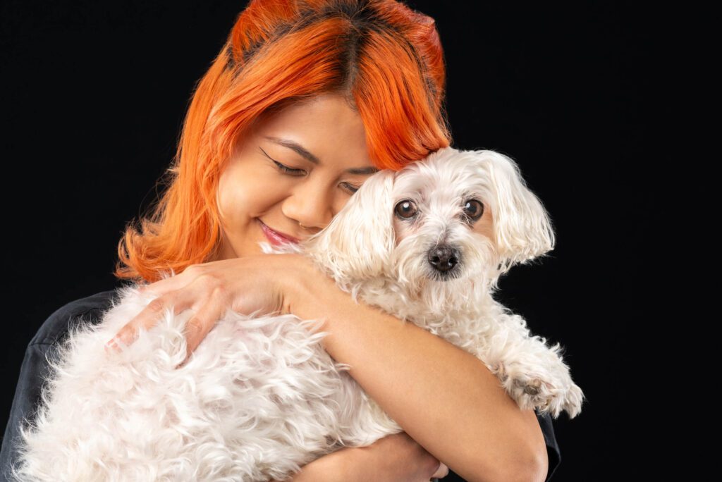 Animal communicator & photographer, Candice C Cusic, and her clients: white fluffy small dog with woman with orange hair