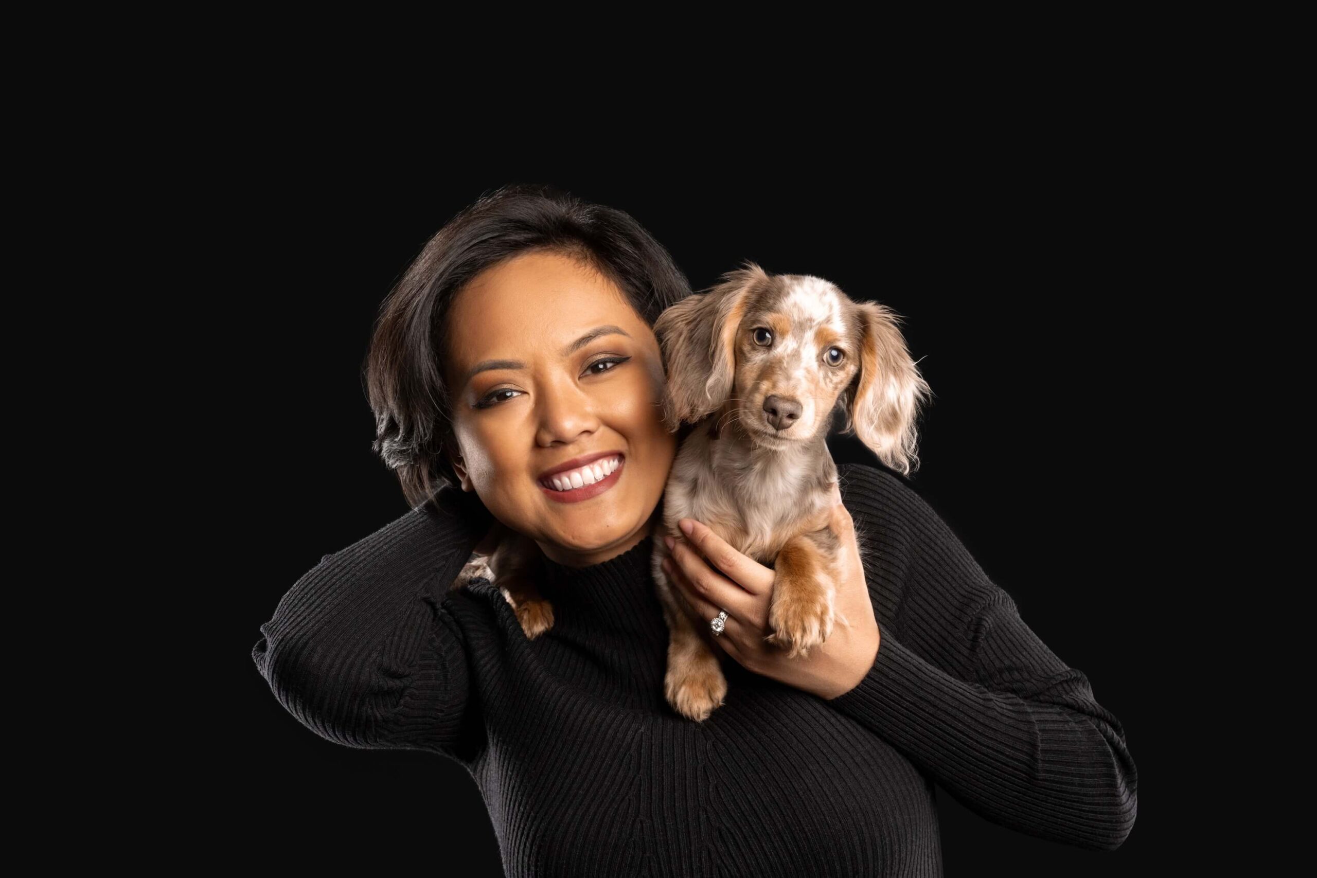 Animal communicator & photographer, Candice C Cusic, and her clients: Women with dark hair in black shirt with small brown and white dog